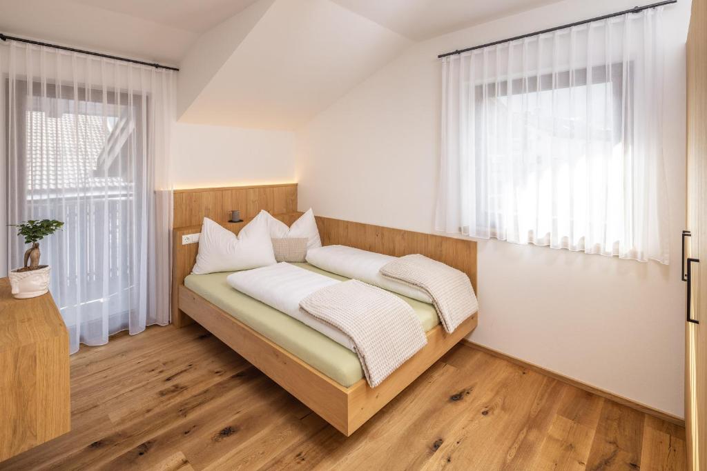 Zum Sonnentor App Pinus في لوتاغو: غرفة نوم بسرير ذو شراشف بيضاء ومخدات بيضاء