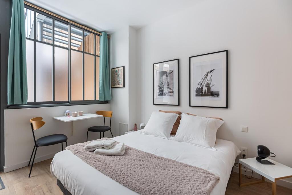 une chambre avec un lit, une table et un bureau dans l'établissement Le Colette - Joli studio en plein centre, à Bordeaux