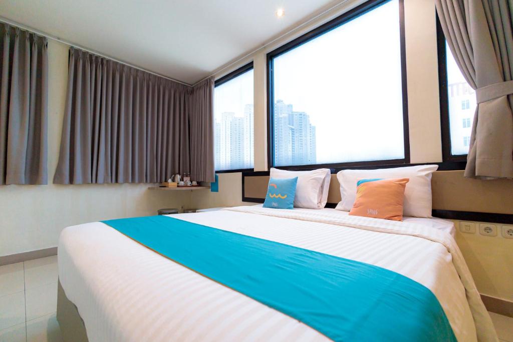 雅加達的住宿－Sans Hotel Liv Ancol by RedDoorz，配有大窗户的客房内的一张大床