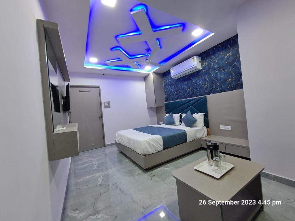 een hotelkamer met een bed en een blauw plafond bij HOTEL KINGDOM in Gandhinagar