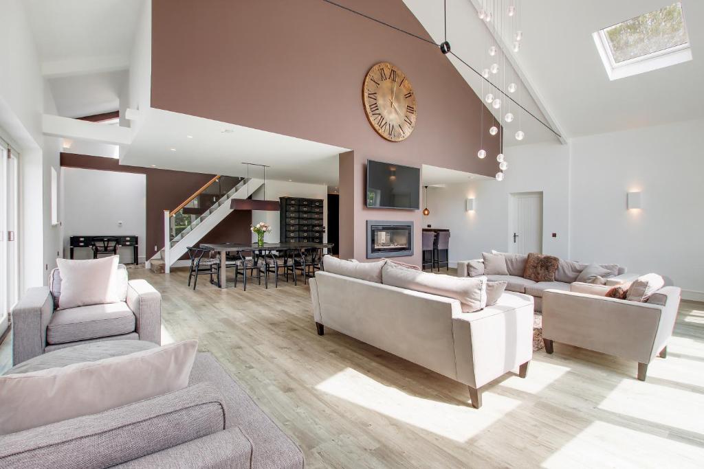 a living room with couches and a clock on the wall at Pass the Keys Perfect and peaceful countryside retreat in Cowden