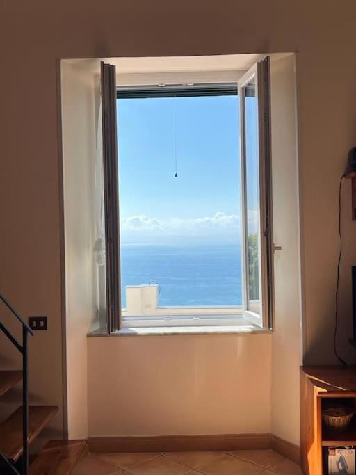 una ventana en una habitación con vistas al océano en Albori bilocale panoramico, en Vietri