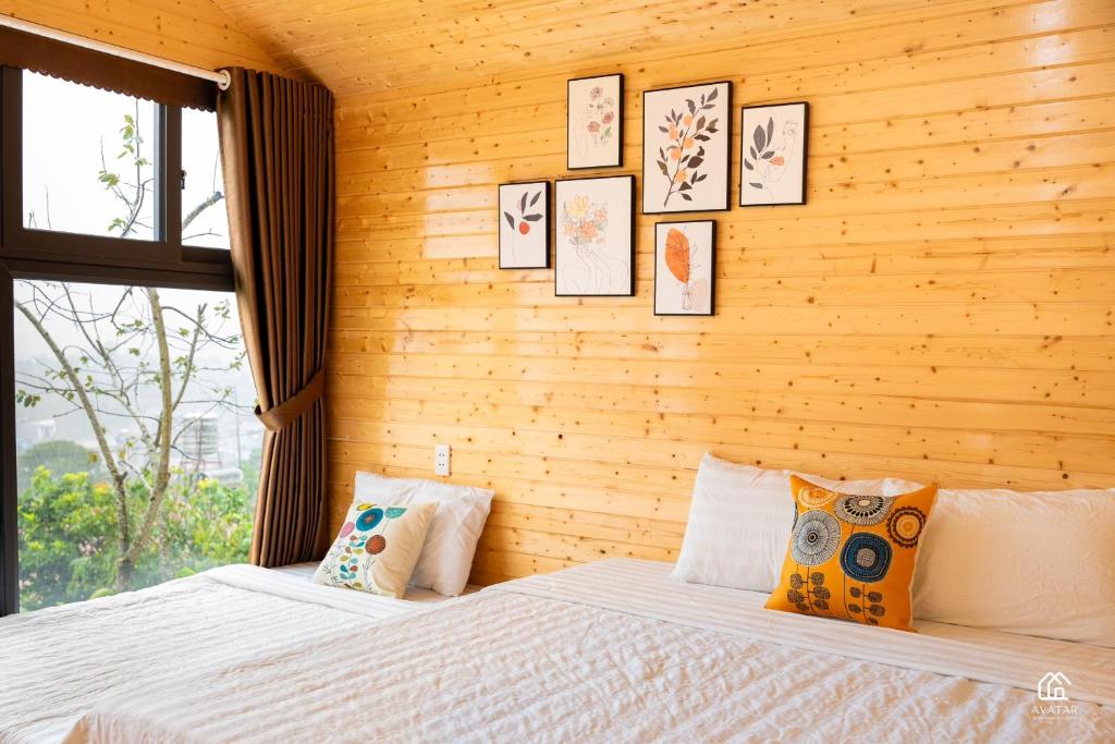 a bedroom with two beds and pictures on the wall at Avatar Homestay & Coffee - Mộc Châu in Mộc Châu