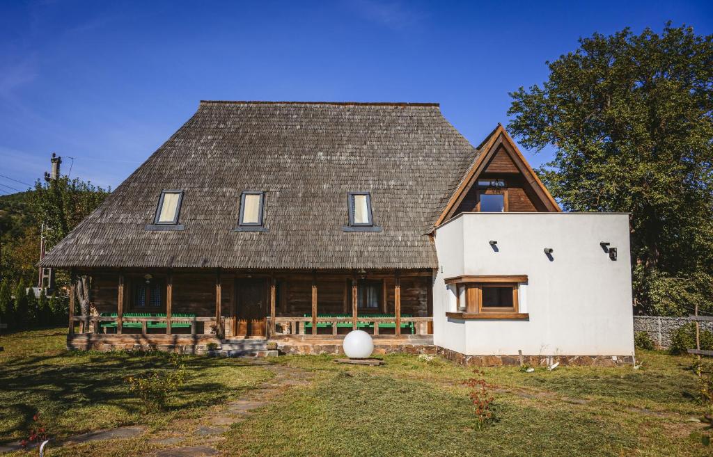 une grande maison blanche avec un toit en gambrel dans l'établissement MMexperience, à Bîrsana