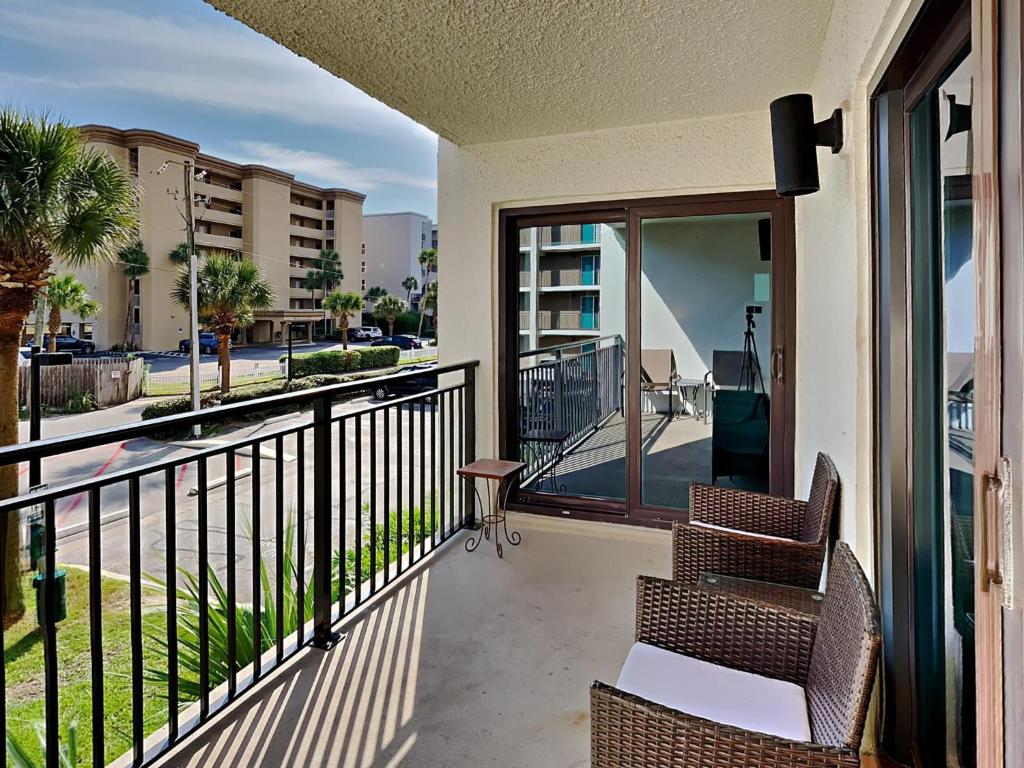 a balcony with two chairs and a view of a street at Emerald Isle fort Walton Beach 209 in Fort Walton Beach