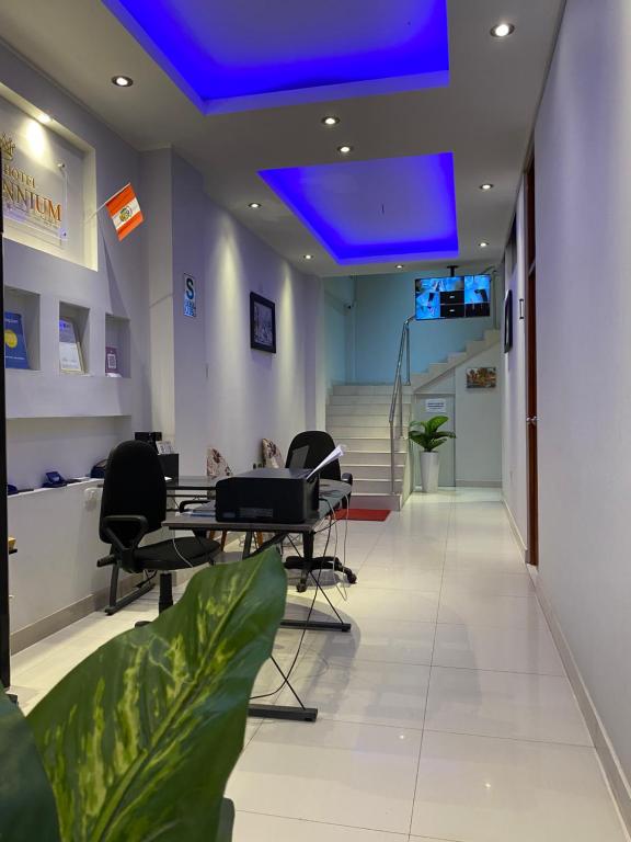 un bureau avec un plafond bleu, des bureaux et des chaises dans l'établissement Millennium Hotel, à San Vicente de Cañete