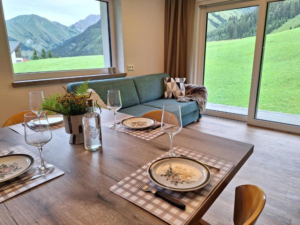 un comedor con una mesa con copas de vino en Berwang 1336 Apartments en Berwang