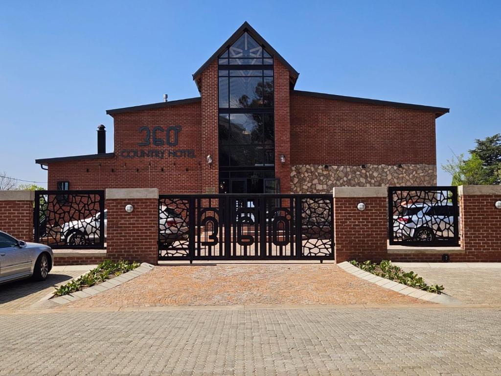 a brick building with a gate in front of it at 360 Country Hotel in Clarens