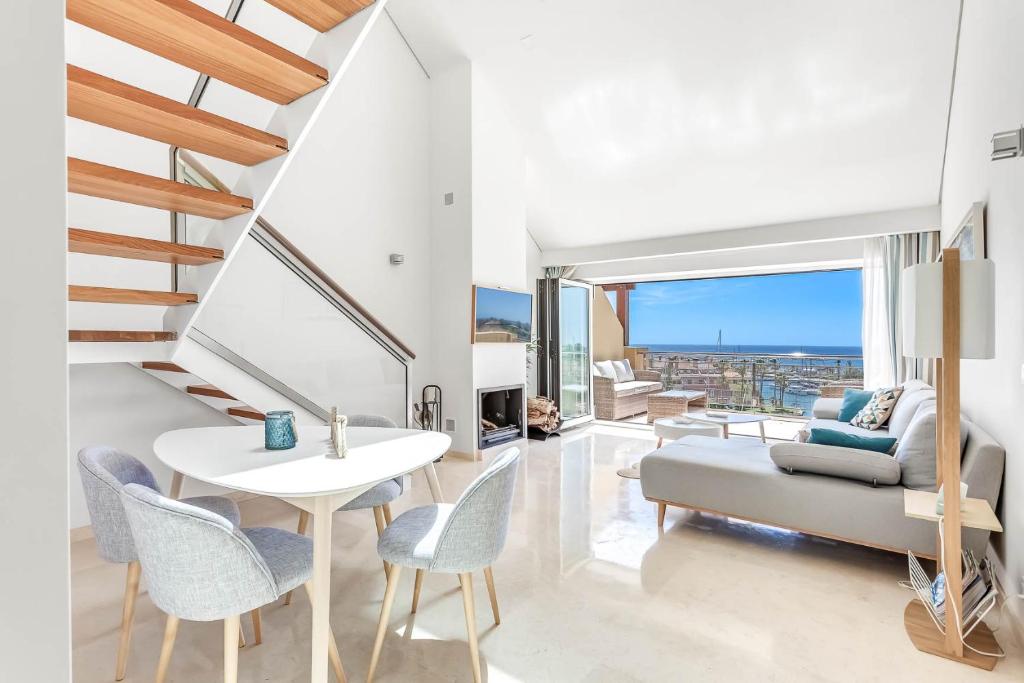 Una sala de estar con una mesa y sillas y un sofá. en Ribera del Marlin Atico/Penthouse, en Sotogrande