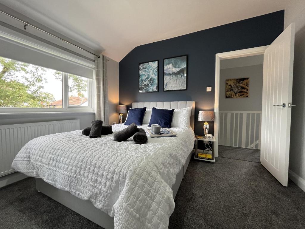 1 dormitorio con 1 cama grande y paredes azules en Modern 3-bed stay-away-home sleeps 6 nr Manchester, en Mánchester