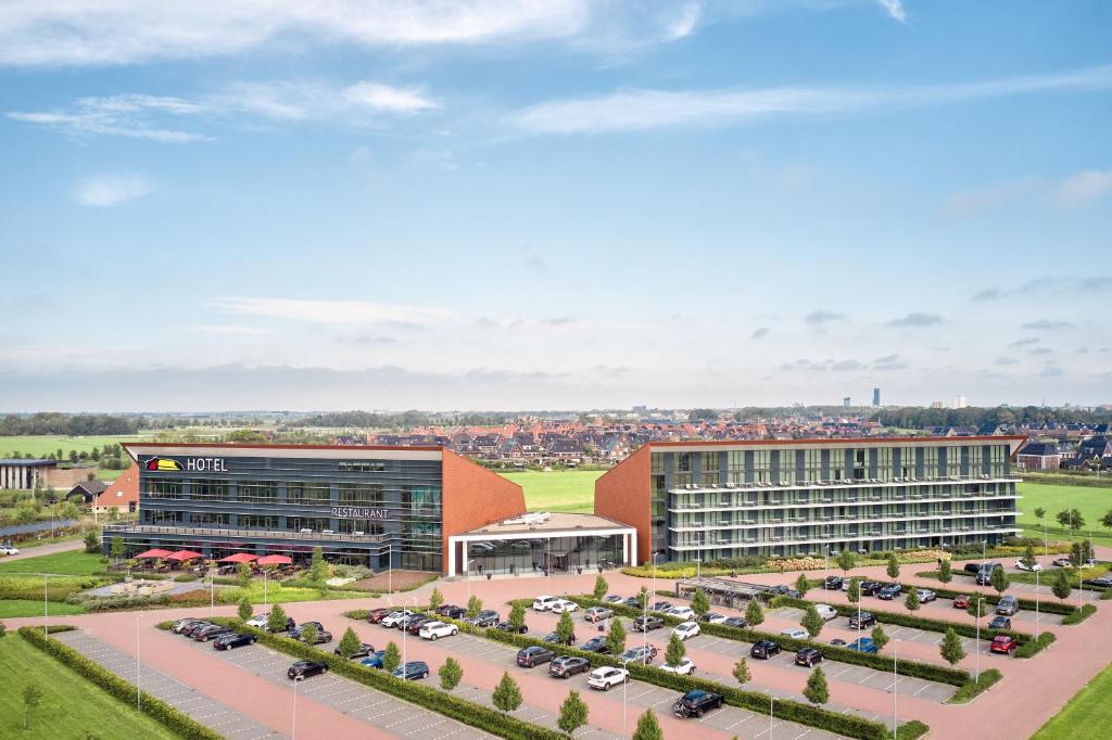 een luchtzicht op een gebouw met auto's geparkeerd op een parkeerplaats bij Van der Valk Hotel Leeuwarden in Leeuwarden