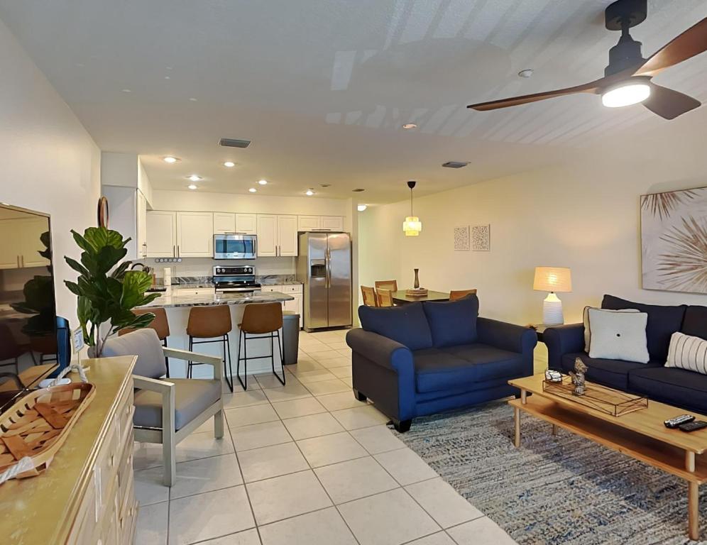 uma sala de estar com sofás azuis e uma cozinha em Casa Mar Y Palmera 202a em Clearwater Beach