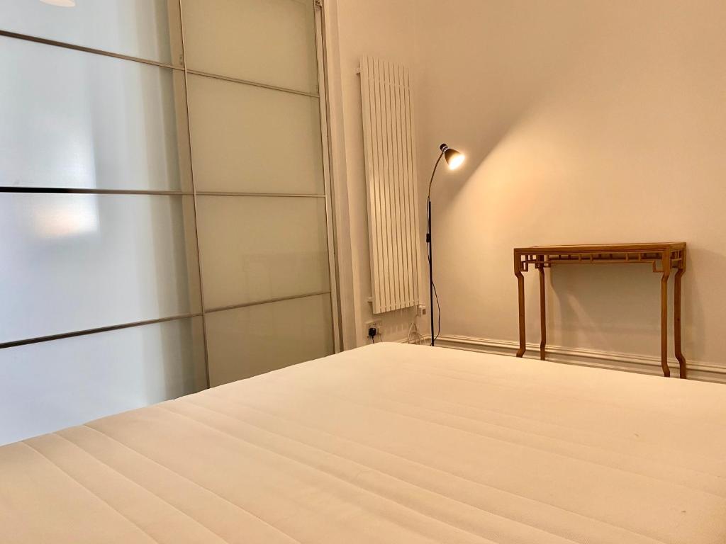 a room with a bed and a lamp at London SW Holiday Apartment - Free parking in London