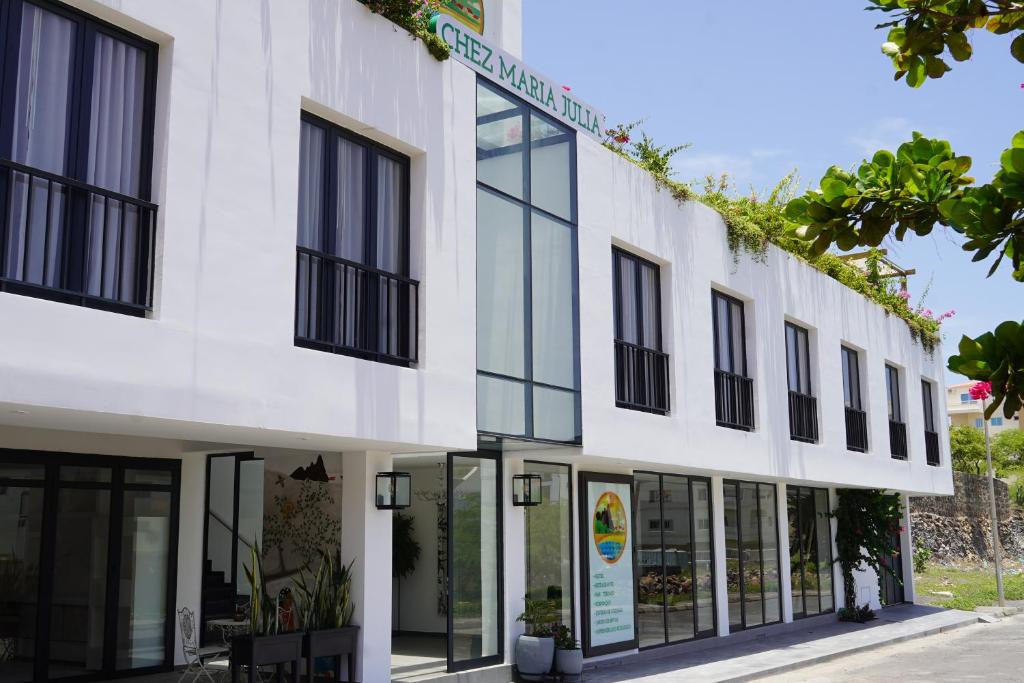 a white building with black windows at Chez Maria Julia Boutique Hotel in Praia