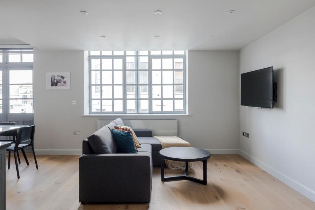 a living room with a couch and a table at London's Calling - Farringdon - by Frankie Says in London