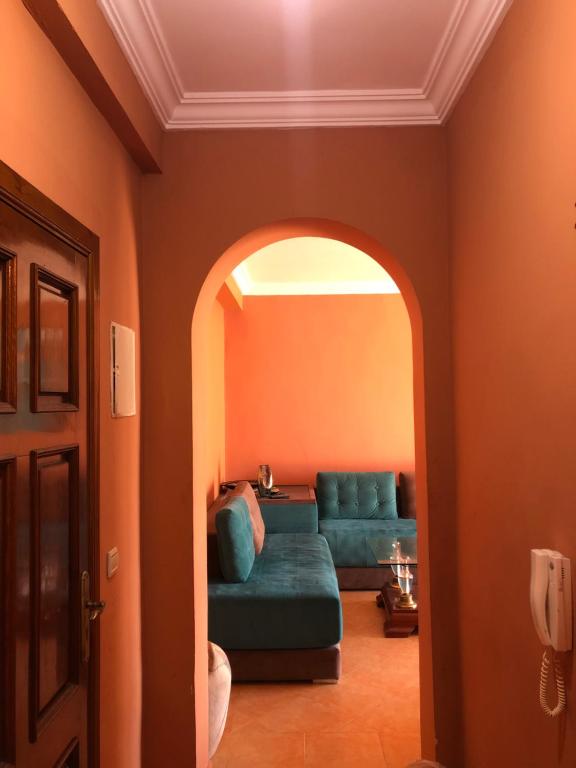een woonkamer met een groene bank en een boog bij Puesta Del Sol in Asilah
