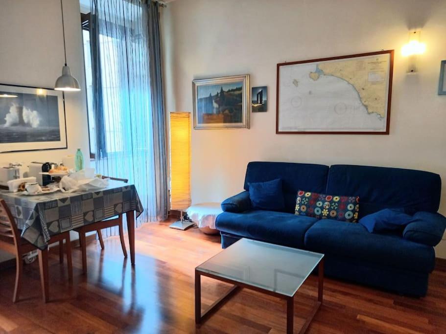 a living room with a blue couch and a table at la casa del viaggiante in Rome