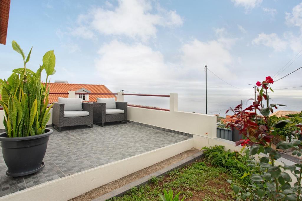 a patio with furniture and plants on a roof at Simão House in Calheta