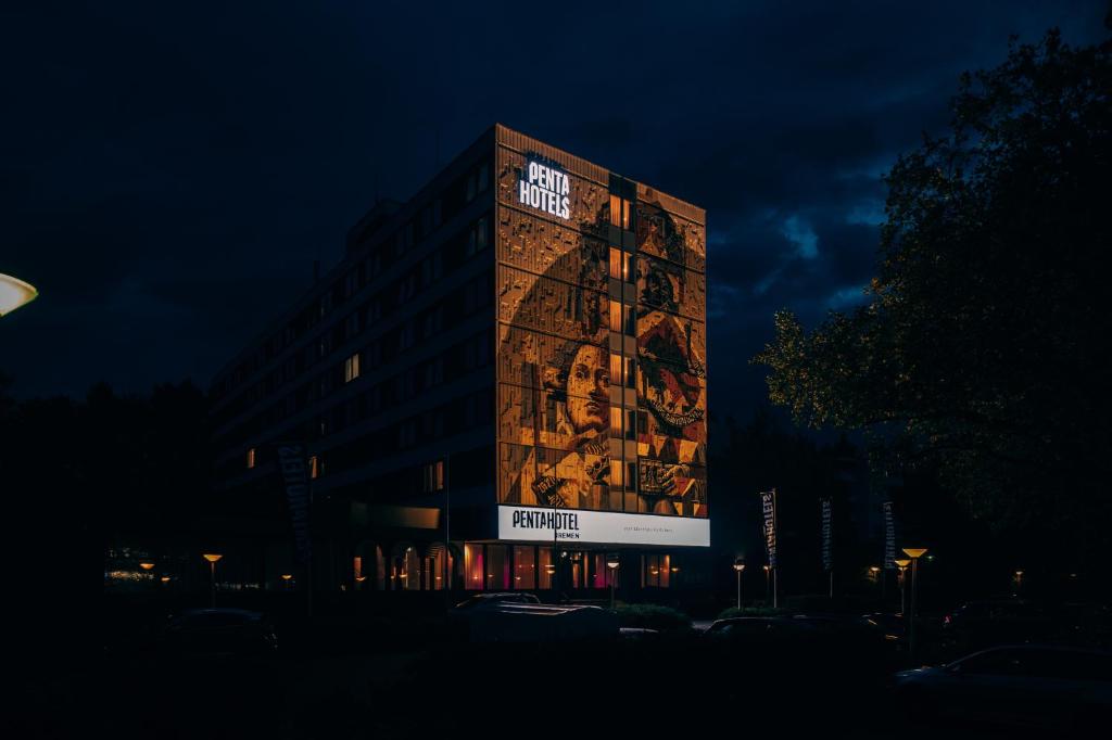 um edifício alto com um cartaz à noite em Pentahotel Bremen em Bremen