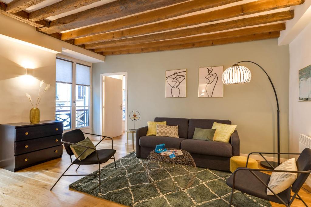 un salon avec un canapé et des chaises dans l'établissement Sweett - Chevalier Saint Georges, à Paris