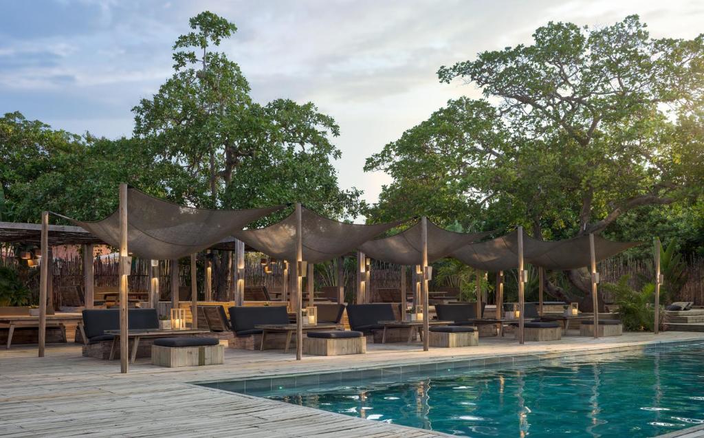a pool with chairs and a tent next to a swimming pool at Casa Uca in Guriú