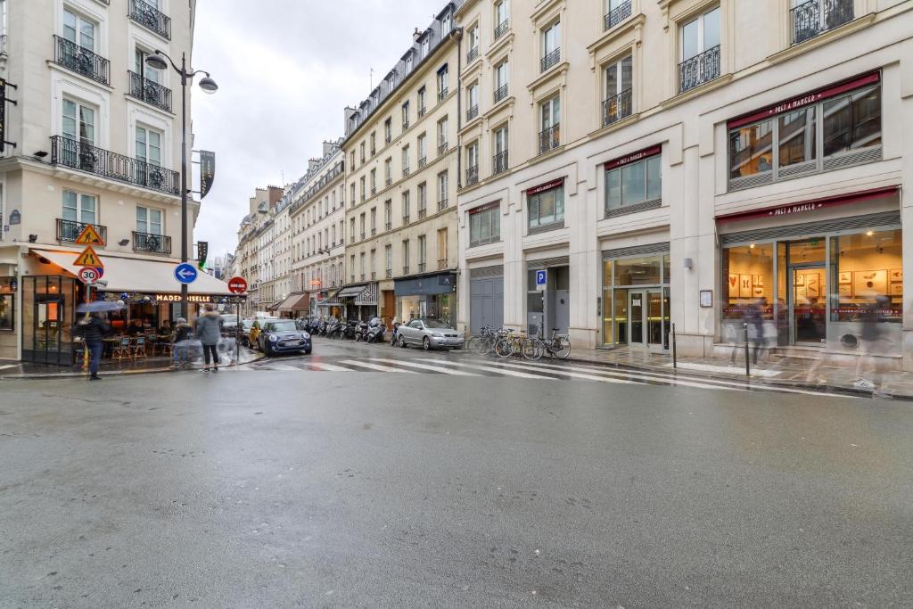 a city street with buildings and people walking on the street at Sweet Inn - Chevalier Saint Georges in Paris