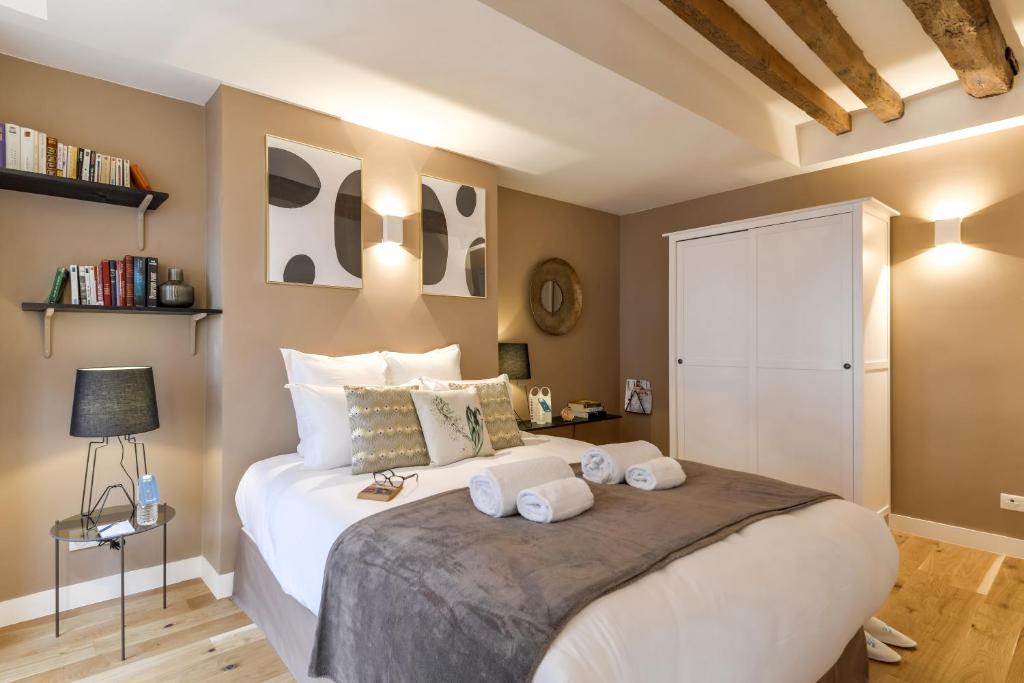 a bedroom with a large bed with towels on it at Sweet Inn - Chevalier Saint Georges in Paris