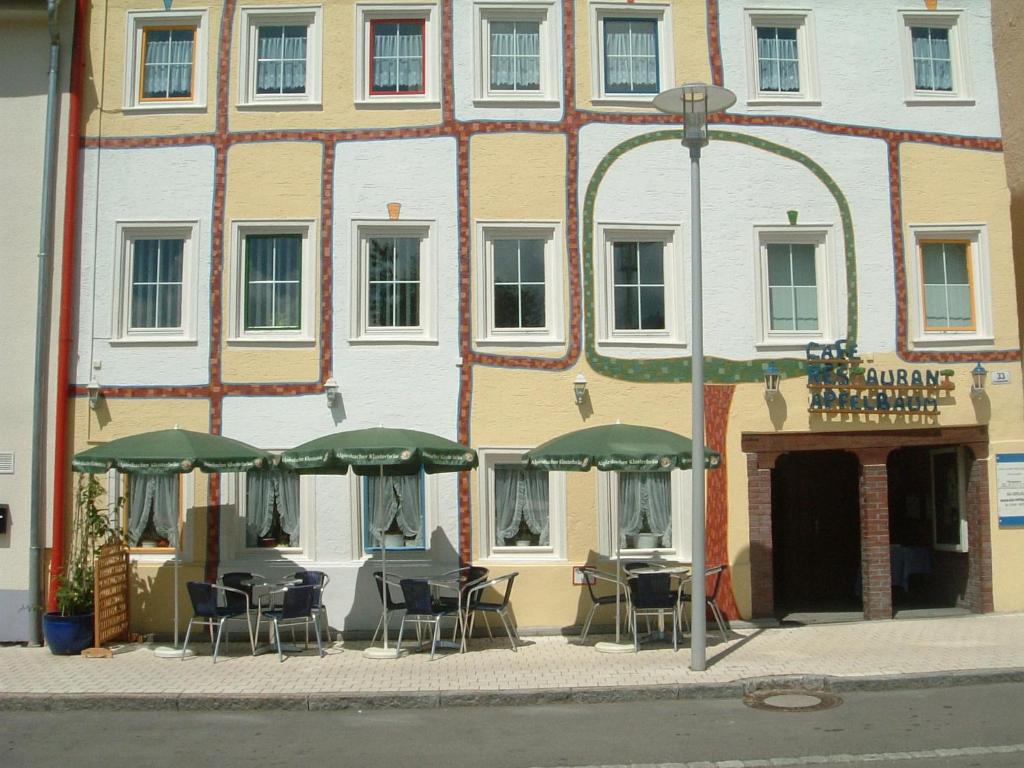 a building with chairs and umbrellas in front of it at Ferienwohnung Apfelbaum in Albstadt
