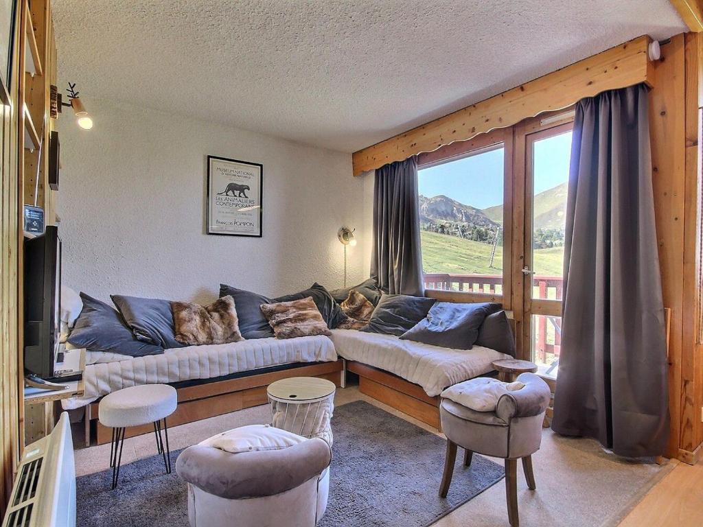 un salon avec un canapé et une fenêtre dans l'établissement Duplex calme au pied des pistes, balcon et animaux acceptés - FR-1-455-232, à La Plagne Tarentaise