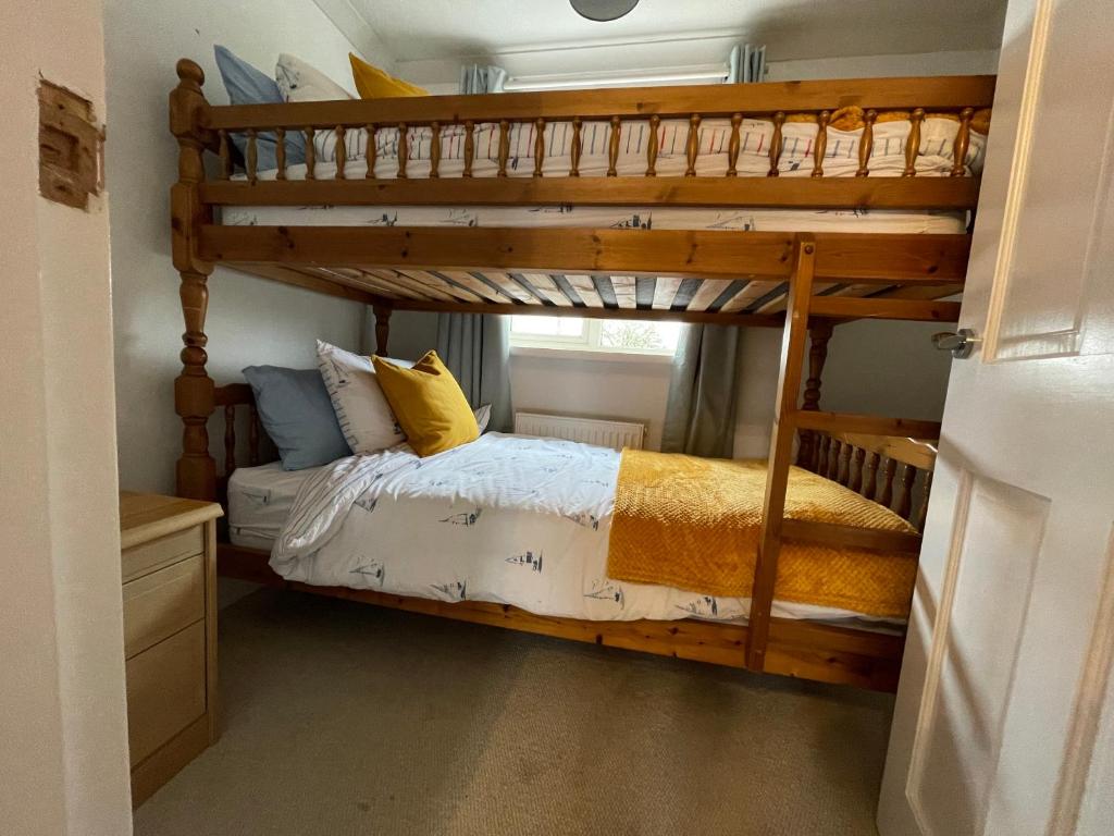 a bedroom with a bunk bed in a room at Charming North Norfolk flint cottage in Baconsthorpe
