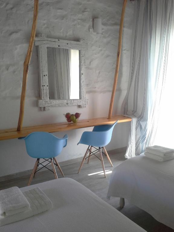 a bedroom with two blue chairs and a desk at Sea Side Studios & Houses in Kalo Livadi