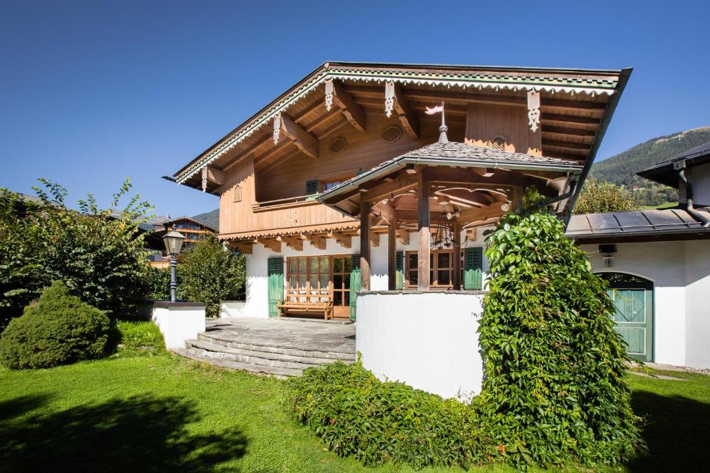 ein Haus mit einem Holzdach und einer Veranda in der Unterkunft Landhaus Wanger in Neukirchen am Großvenediger