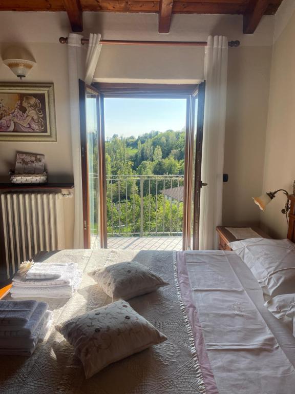 1 dormitorio con 1 cama grande y ventana grande en Il Nido dell’Aquila, en Moncalvo