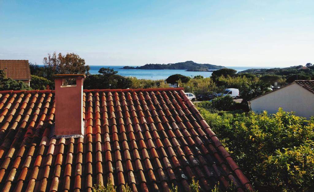 a red roof with a view of the ocean at Loft T3 Duplex Vue Mer Porquerolles in Hyères