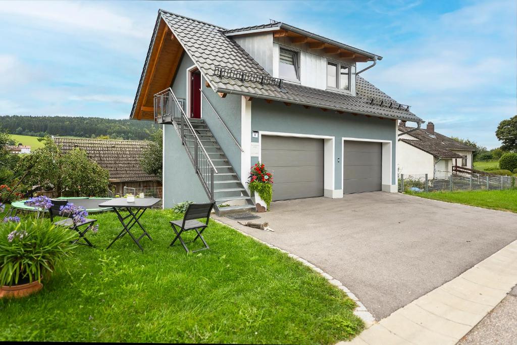 a white house with a garage and a patio at Ferienwohnung Knecht in Georgenberg