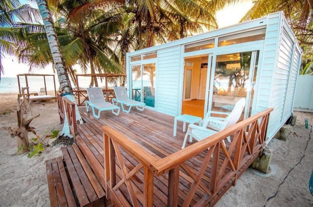 una casa blu sulla spiaggia con sedie e tavoli di Hotel Reina del Mar By Dorado a San Andrés