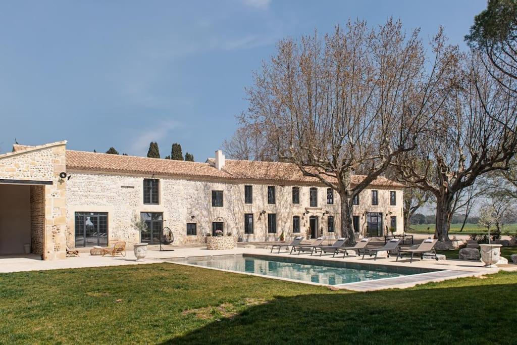 um grande edifício de pedra com uma piscina no quintal em Mas Mandine, en Provence em Arles