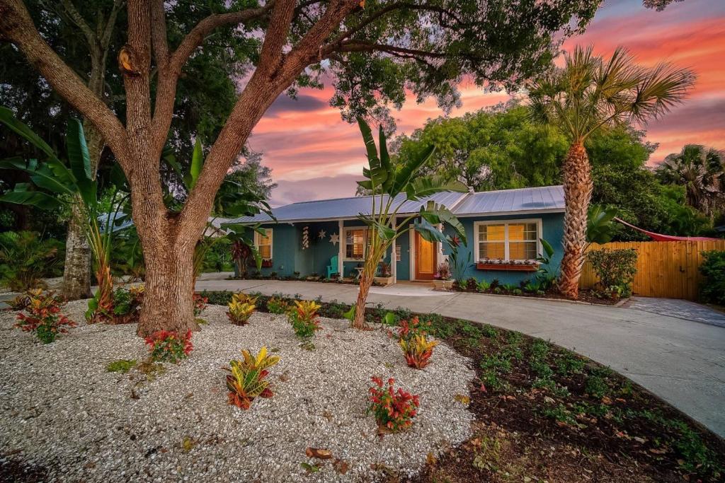 una casa con un árbol y flores en un patio en The Nest, en Sarasota