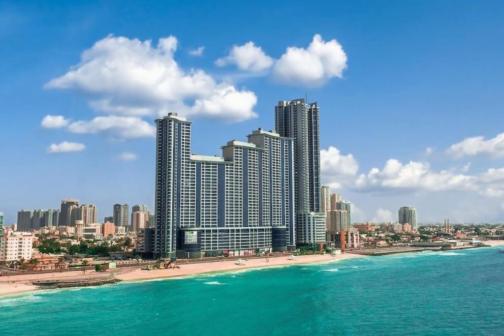a view of a beach with tall buildings and the ocean at Cozy 1BH Apt next to the sea! in Ajman 