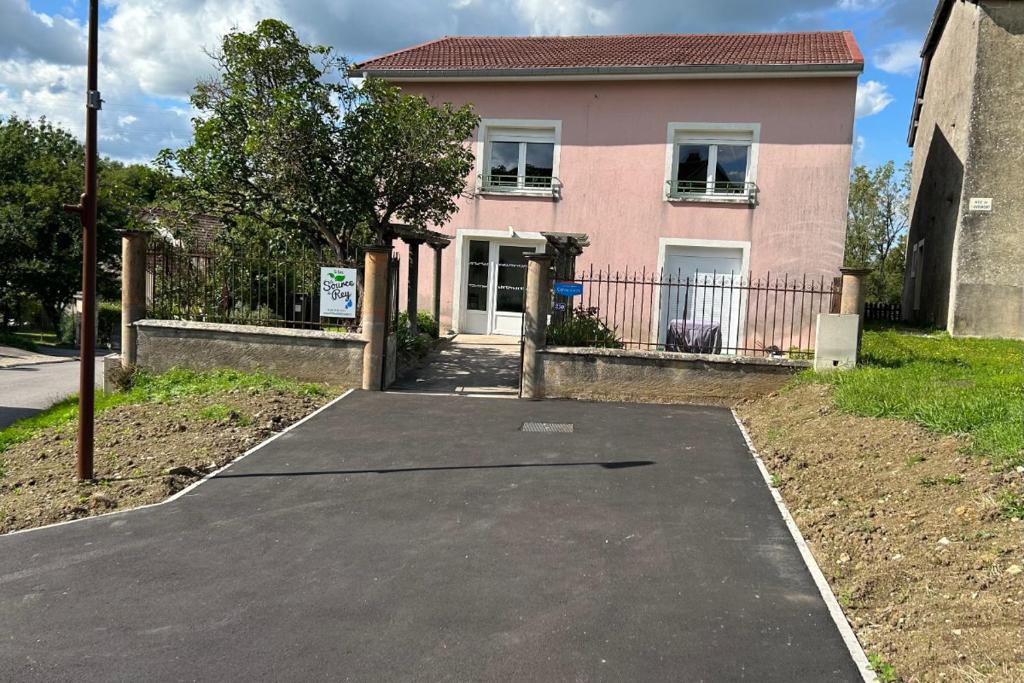 a driveway in front of a pink house at Appartement RDC in Remoncourt