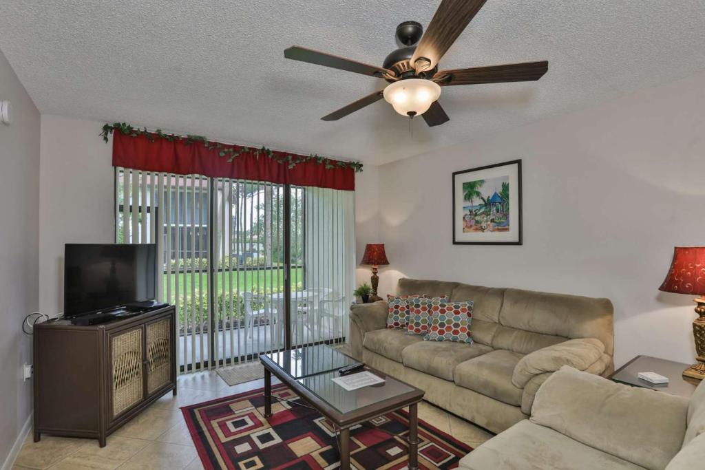 a living room with a couch and a ceiling fan at Shorewalk Condominium in Bradenton