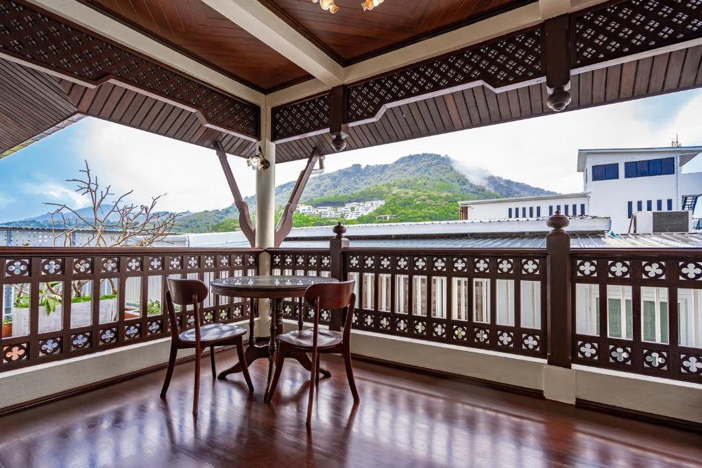 a balcony with a table and chairs and a view at The Color Kata in Kata Beach