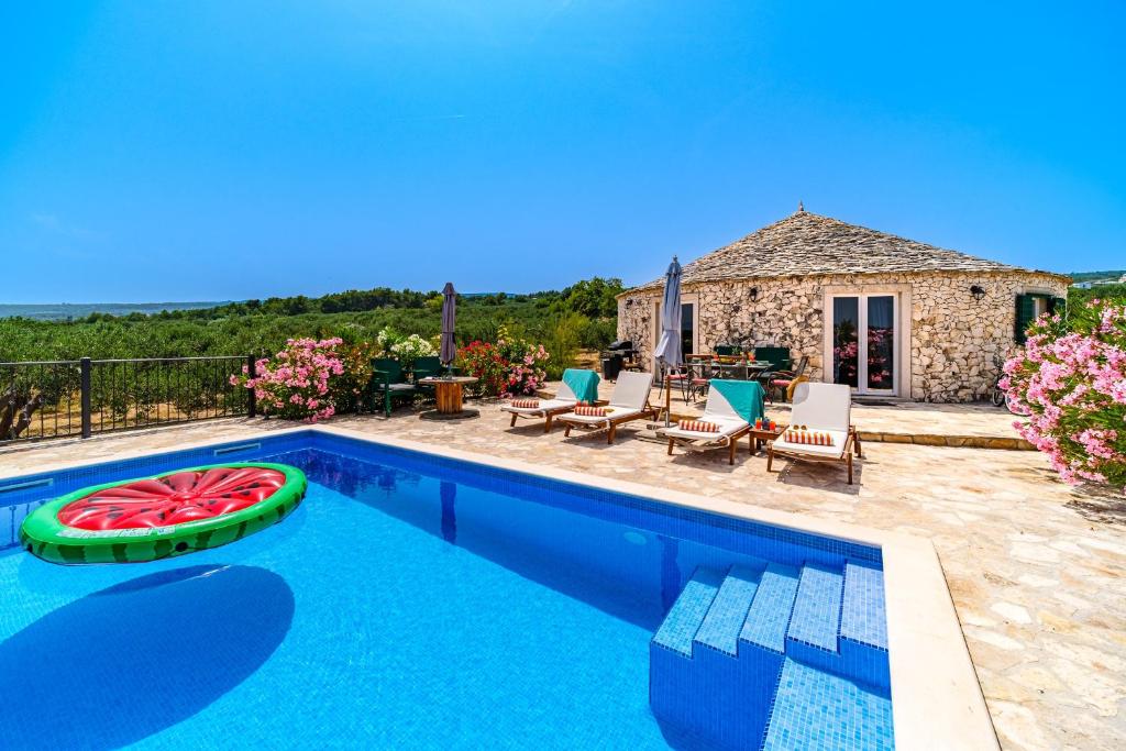 a villa with a swimming pool and a house at Island Getaway - Heritage House with heated pool in Mirce