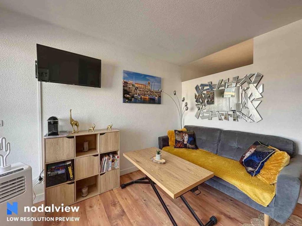 un salon avec un canapé et une table dans l'établissement Ipanema, à Canet