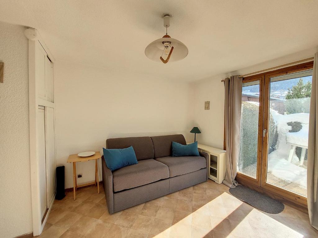 een woonkamer met een bank en een raam bij Charmant studio avec terrasse in Praz-sur-Arly