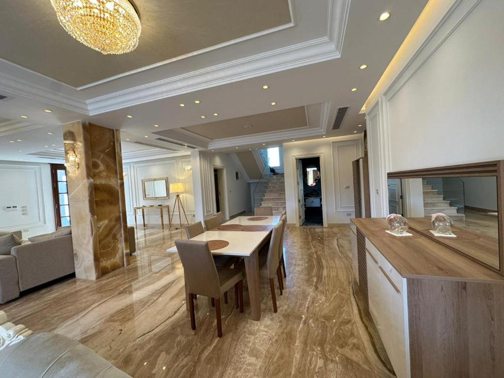 uma sala de jantar com mesa e cadeiras num edifício em Al Sawah Stand Alone Villa With Private Pool em Sheikh Zayed