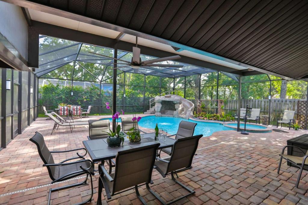 un patio con mesa y sillas y una piscina en Cypress Lake - Pool Home, en Sarasota