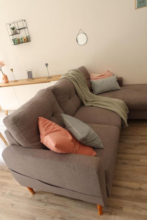 a couch with pillows on it in a living room at * La Tour : Vue imprenable sur la ville * in Luxeuil-les-Bains