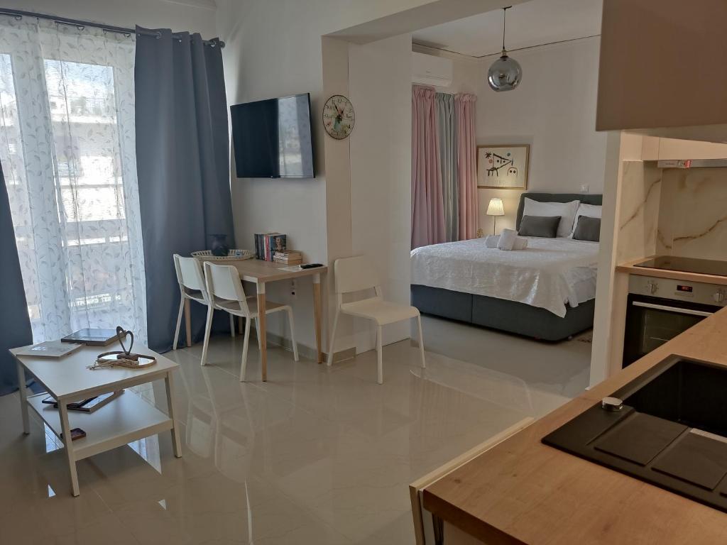 ein Schlafzimmer mit einem Bett und einem Tisch sowie ein Esszimmer in der Unterkunft Διαμέρισμα studioJoy4stay στο Χαλάνδρι in Athen