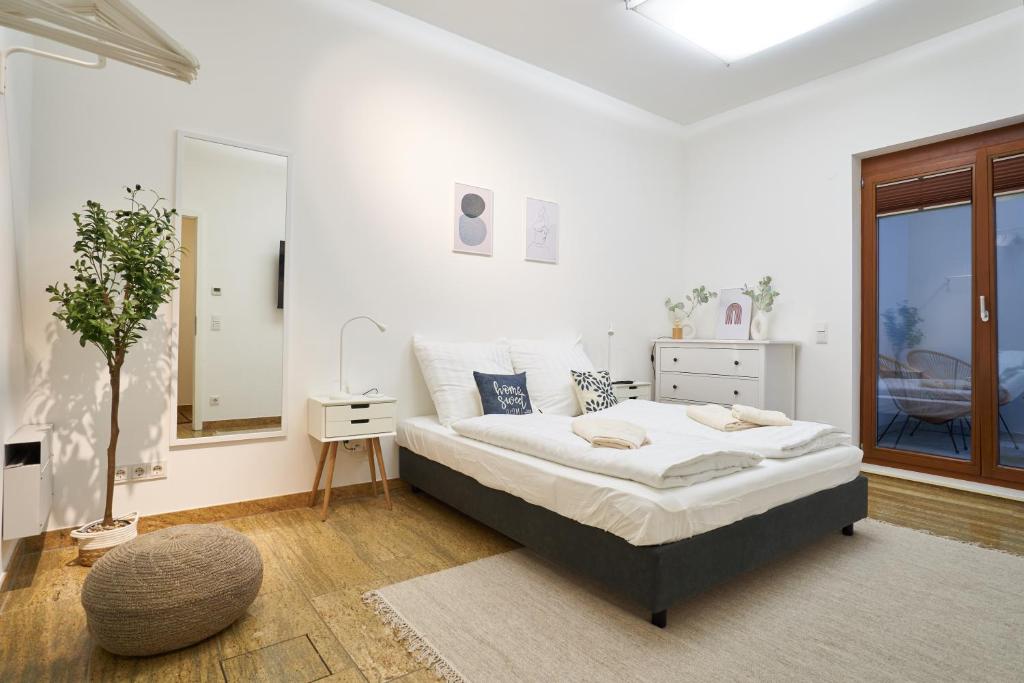 Un dormitorio blanco con una cama y una ventana. en Global Living - Design Apartments I City Center I Balcony I Smart-TV I Kitchen I Dresden, en Dresden